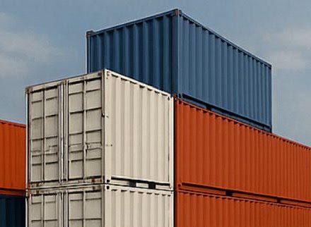 Pilha de containers maritimos azuis em patio logistico